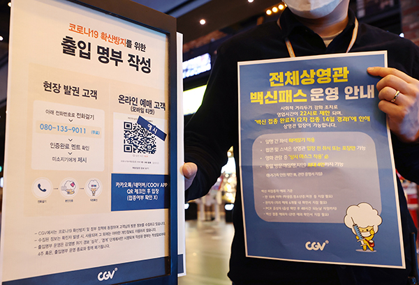 영화관, 대형마트 등에 대한 방역패스 적용이 해제된 지난 18일 서울 용산구 CGV 용산아이파크몰점에서 직원이 방역패스 안내문을 교체하고 있다