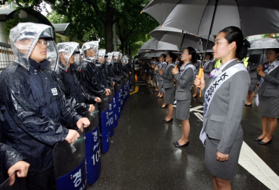 113일째 파업 중인 KTX 여승무원 100여명이 2006년 6월21일 오후 서울역 광장에서 집회를 한뒤 철도공사의 직접고용을 요구하며 청와대까지 가두시위를 하던 중 세종로 정부청사 앞에서 시위를 하고 있다.