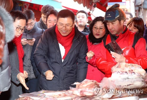 자유한국당 황교안 대표가 31일 오후 서울 영등포구 대림동 우리시장을 방문해 물건을 구매하고 있다