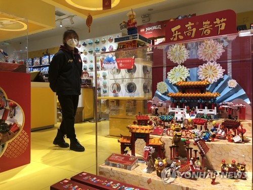 21일 중국 후베이성 우한(武漢)시의 쇼핑몰 완다광장의 레고 가게에서 한 마스크를 쓴 직원이 서 있다. 2020.1.21