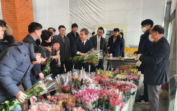 김승수 전주시장이  시청 로비에서 지역 화훼농가가 연 장터를 찾아 꽃다발을 사고 있다.