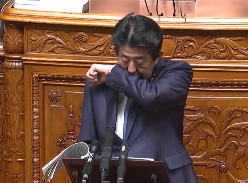 아베 신조(安倍晋三) 일본 총리가 6일 오전 참의원 본회의에서 답변서를 읽던 중 기침이 나오려하자 소매로 입을 가리고 있다.