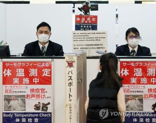 일본 나리타(成田)공항에서 당국자가 입국자들의 체온을 측정하고 있다.