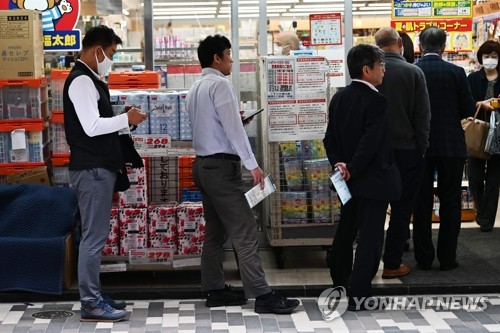 일본 정부의 신종 코로나바이러스 감염증(코로나19) 긴급사태 선포 후에도 감염 확산에 제동이 걸리지 않는 가운데 지난 22일 도쿄의 한 약국에서 마스크를 사려는 사람들이 줄지어 서서 차례를 기다리고 있다.