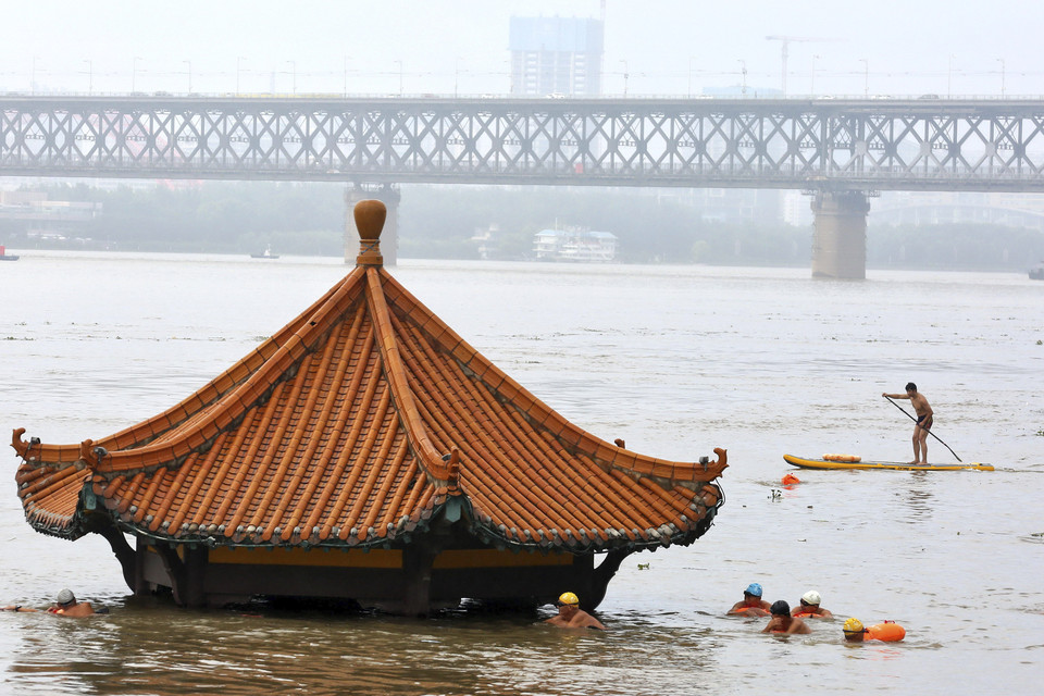 홍수로 물에 잠긴 중국 양쯔강변의 정자= 중국 후베이성에 최근 내린 폭우로 우한의 양쯔강이 범람하면서 물에 잠긴 정자 곁을 8일 주민들이 헤엄쳐 건너고 있다.