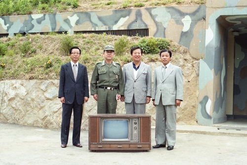 TV가 귀하던 시절의 접경지 풍경=흑백 TV를 군부대 위문품으로 들고 온 당시 권귀태 파주군수(오른쪽)와 1군단 김윤호 중장(왼쪽에서 두번째)이 TV를 앞에 두고 기념촬영하고 있다. 정확한 장소는 현재 확인할 수 없으며, 촬영시기는 1980∼1981년으로 추정된다. 2020.7.26 [파주중앙도서관 제공. 재판매 및 DB 금지]