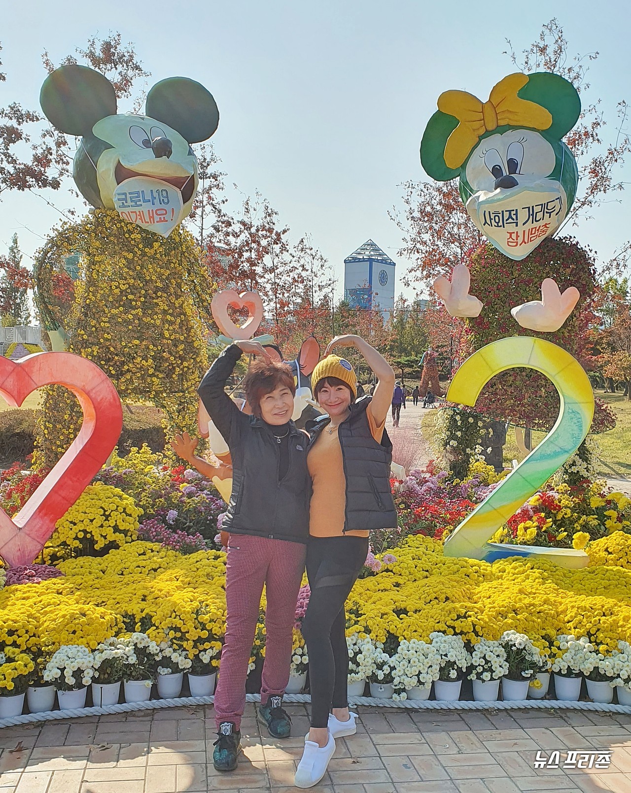 대전 유성 국화전시회가 유림공원에 아름다운 국화로 수 놓아진 가운데, 30일 오후 엄마 이왕비씨와 딸 박윤아씨가 국화로 장식된 미키마우스를 배경으로 모녀가 하트를 그리며 인생사진을 찍고 있다./ⓒ이현식 기자