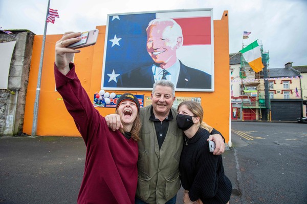 조 바이든 미 대통령 당선인의 벽화 앞에서 사진을 찍는 아일랜드 밸리나 마을 주민들
