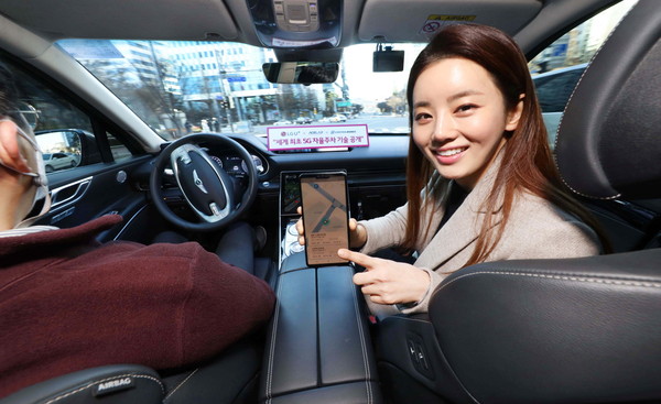LG유플러스 모델이 서울시 상암 5G 자율주행 시범지구에서 5G 자율주행차 'A1'에 탑승해 모바일 앱으로 차량의 현재 위치를 확인하는 모습. / ⓒLG유플러스