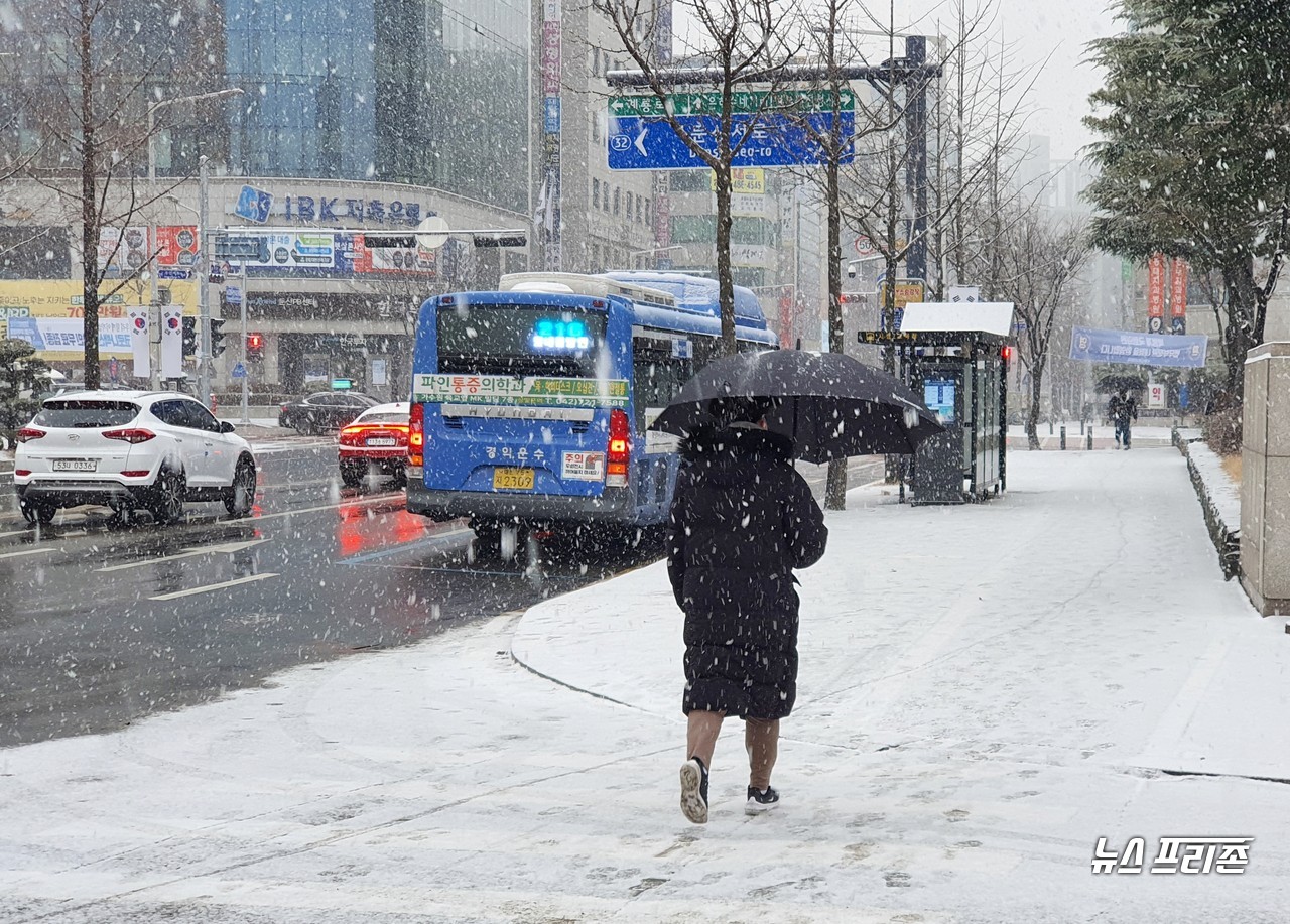 전국 곳곳에 대설주의보가 내려진 18일 오전 9시쯤, 영하 -1도의 기온을 보이는 대전 서구 둔산동에는 눈발이 점점 굵어지며 내리는 가운데, 우산을 쓴 시민이 바쁜 걸음을 재촉하고 있다./ⓒ이현식 기자