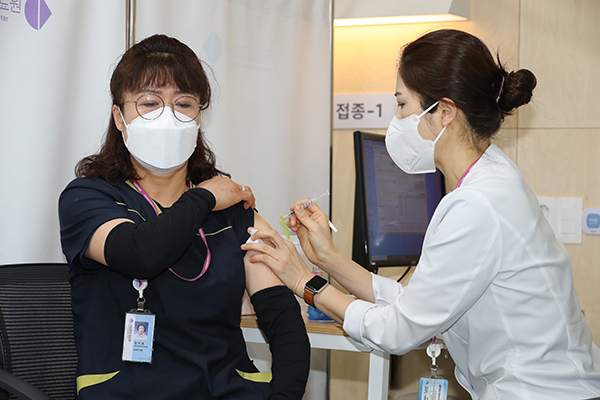 지난 27일 오전 서울시 중구 을지로 국립중앙의료원 중앙예방접종센터에서 화이자 백신 1호 접종을 받은 환경미화원 정미경 씨가 접종을 받고 있다.