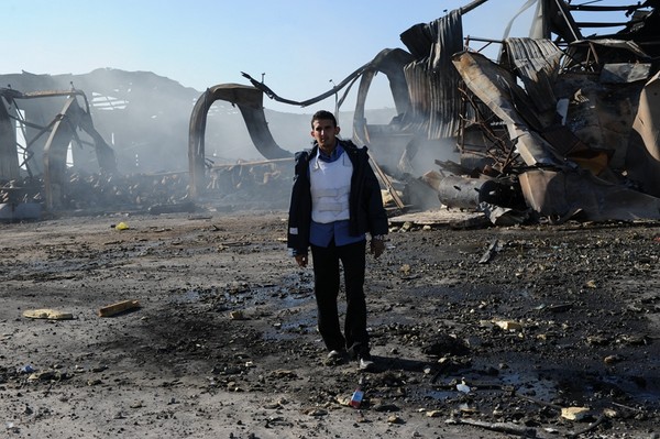 2011년 3월 22일, 리비아 수도 트리폴리에서 한 직원이 폭격을당한 후 해군 공장의 폐허 밖에 서 있었다.