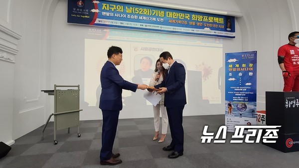 우측 빨간색 복장을 한 맨발의 조승훈씨가 기록 도전을 하는 퍼포먼스를 하는 가운데 전남체육회 김재무 회장은 '한국도전인 대상'을 수여 했다. ⓒ 장건섭 기자