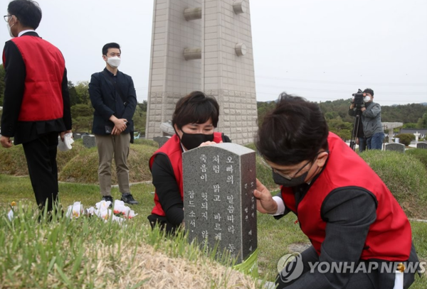 사진은 국민의힘 조수진 의원이 10일  광주 5•18 묘지를 찾아 참배하고 묘비를 닦고 있다.