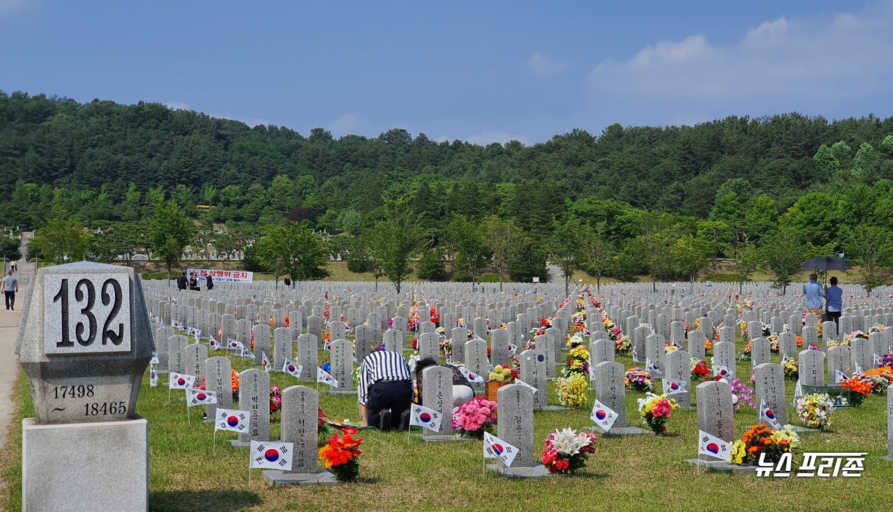 현충일을 맞은 6일 오후 국립대전현충원 국군 묘역에서 군 유가족이 나라를 위해 목숨을 바친 가족의 넋을 기리며 묘비를 향해 참배를 하고 있다./ⓒ이현식 기자