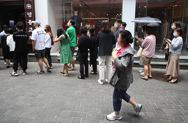 지난 21일 서울 명동의 한 음식점 앞에 시민들이 좁은 간격을 두고 입장을 기다리고 있다.