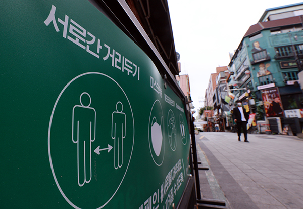 서울 용산구 이태원 세계음식거리 한 가게 입구에 사회적 거리두기와 코로나19 방역 캠페인 내용이 적힌 배너가 세워져 있다.