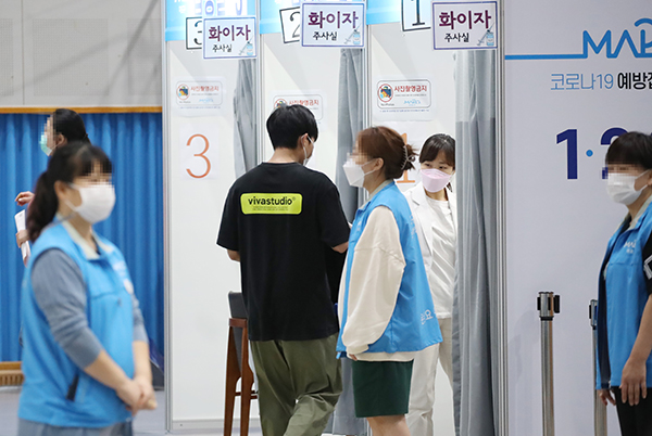 서울 마포구민체육센터에 마련된 코로나19 예방접종센터에서 관계자들이 시민들을 접종실로 안내하고 있다.