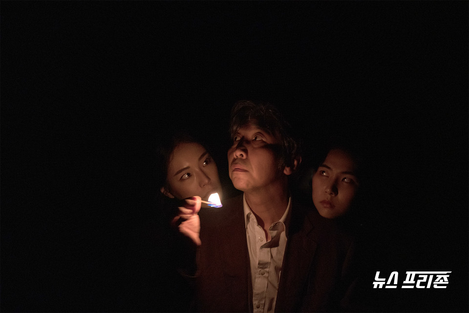 "준생" 공연사진 | 한치의 불빛도 보이지 않는 어둠 속 촛불만을 의지해 주변을 살피는 한 남자의 뒤로 새까만 그림자가 보인다. /(사진=Aejin Kwoun)