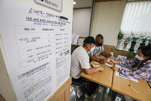 서울 영등포구 대림동 영등포보건소 분소에서 인근 지역에 거주 중인 국내 미등록 외국인들이 코로나19 백신 접종을 하기 위해 직원과 상담하고 있다.