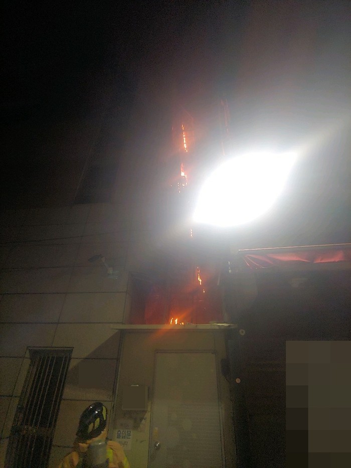 에어컨 실외기에서 발생한 것으로 추정되는 불이 건물 외벽을 타고 번지고 있다. (사진=부산경찰청)