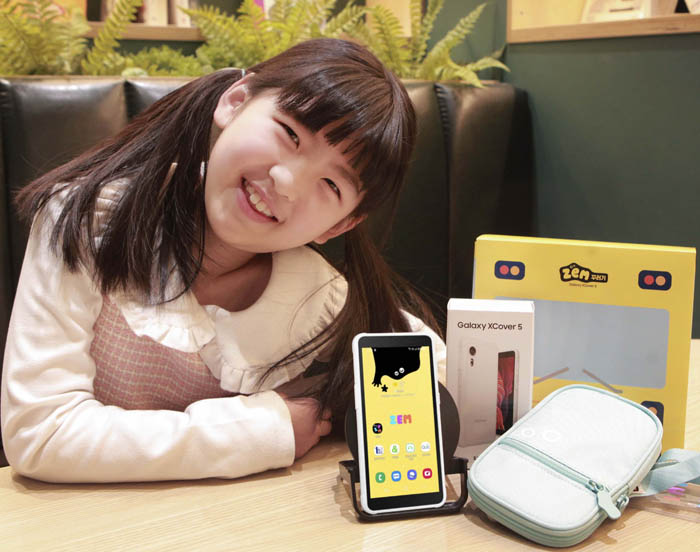 LTE 키즈용 스마트폰 'ZEM 꾸러기 폰'을 SKT 어린이 모델이 들고 있다. (사진=SKT)
