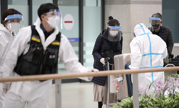인천국제공항 제1여객터미널에서 여객기 탑승자들이 입국장에서 방역관계자의 안내를 받고 있다.