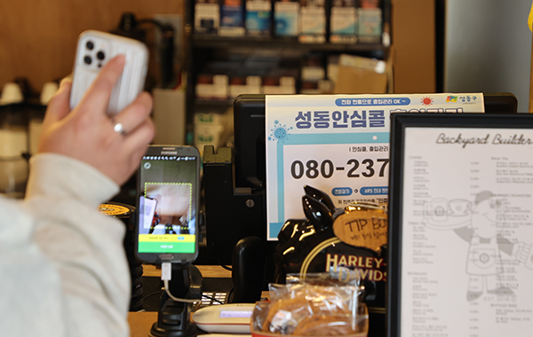 서울 시내 카페에서 방문 고객이 전자출입명부 QR코드를 태그하고 있다.