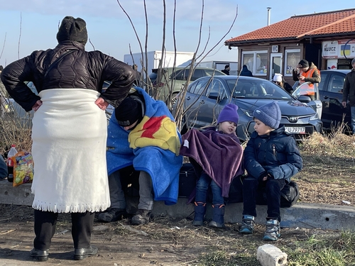 담요를 두르고 몸녹이는 우크라이나 피란민들 = 메디카 국경검문소 앞에서 도보로 폴란드 국경을 넘은 피란민들이 담요를 두르고 몸을 녹이고 있다.2022.2.27