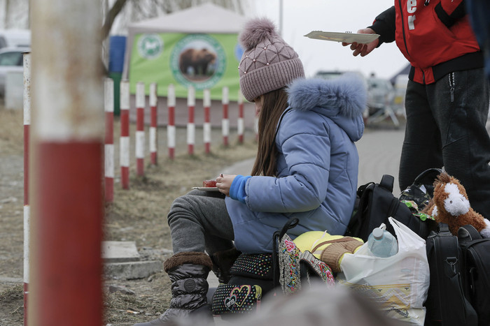 4일(현지시간) 폴란드 국경도시 메디카로 피란 온 우크라이나의 한 소녀가 길거리에 앉아 끼니를 때우고 있다. 유엔난민기구(UNHCR)에 따르면 지난달 24일 우크라이나를 침공한 러시아군이 공세를 강화하면서 우크라이나 시민 100만여 명이 이웃 국가로 피신한 것으로 집계됐다.