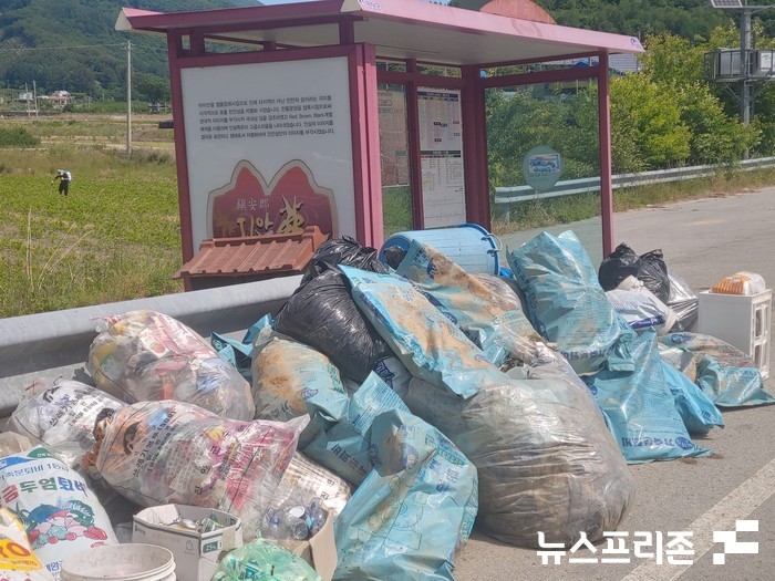 사진= 미곡마을 버스정류장옆도로에 각종쓰레기가쌓여있는 모습