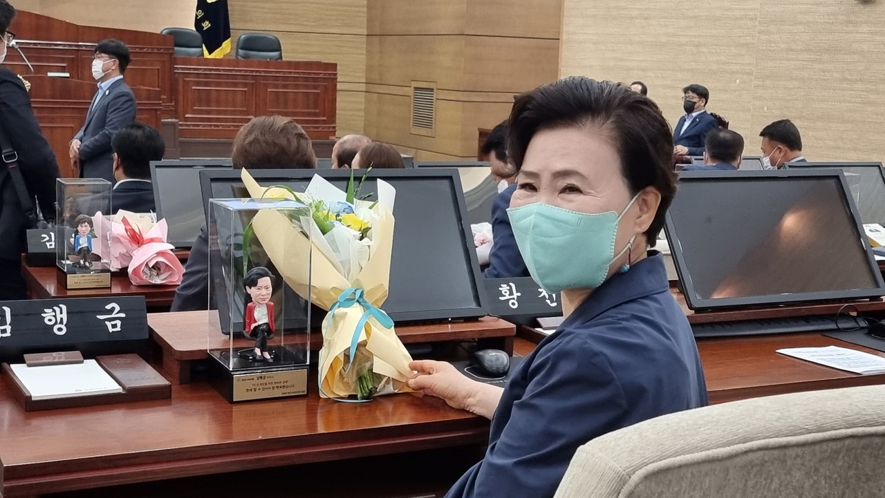 제8대 천안시의원 모두 본인을 모델로 제작한 피규어 선물. 김행금 의원이 피규어와 꽃다발을 선물받고 기뻐하고 있다.