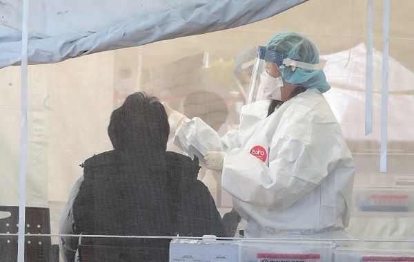 부산에서 오미크론 변이 바이러스의 지역 감염이 확산세를 보인 지난 13일 오후 사상구보건소 선별진료소를 찾은 시민들이 코로나19 검사를 받고 있다.