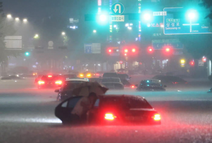 폭우에 속수무책 = 8일 밤 서울 강남구 대치역 인근 도로에서 차량이 침수되자 운전자가 대피하고 있다. 2022.8.8