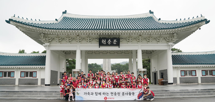 롯데건설 임직원과 가족들이 현충문 앞에서 봉사활동 기념 촬영을 하고 있다. (사진=롯데건설)