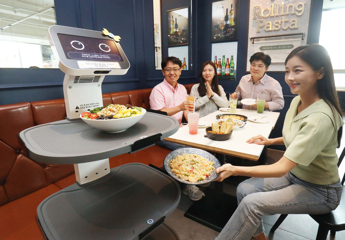 서울 구로구 롤링파스타 매장에서 LG 클로이 서브봇이 가져온 음식을 손님이 꺼내고 있다. (사진=LG유플러스)