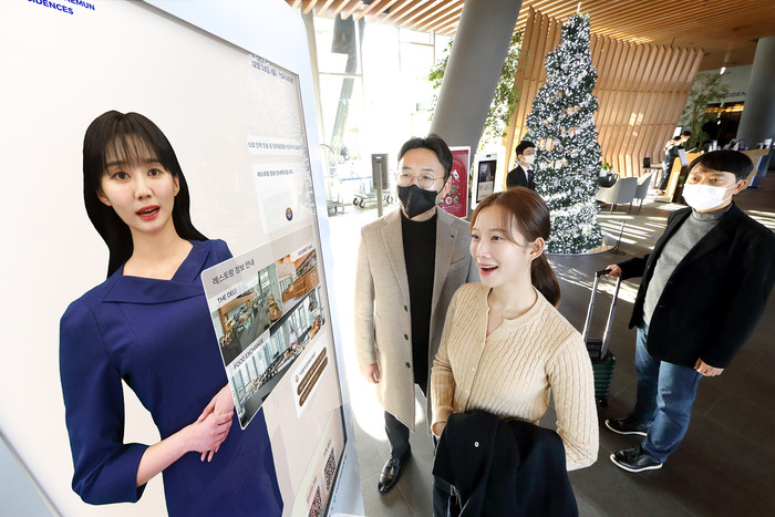 모델이 노보텔 앰배서더 서울 동대문 호텔＆레지던스 1층 로비에 설치된 'AI 컨시어지' 앞에서 호텔 서비스 안내를 받고 있다. (사진=KT)