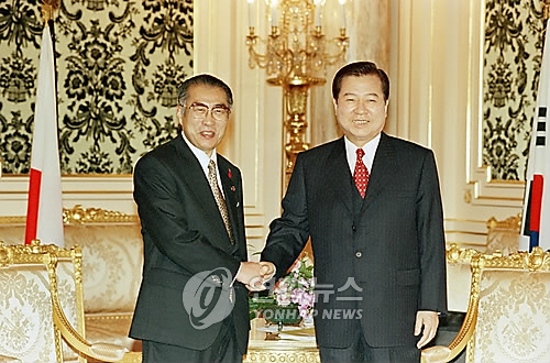 김대중 대통령과 오부치 게이조 일본 총리가 1998년 10월8일 정상회담에 앞서 악수를 하고 있다. [연합뉴스 자료사진]