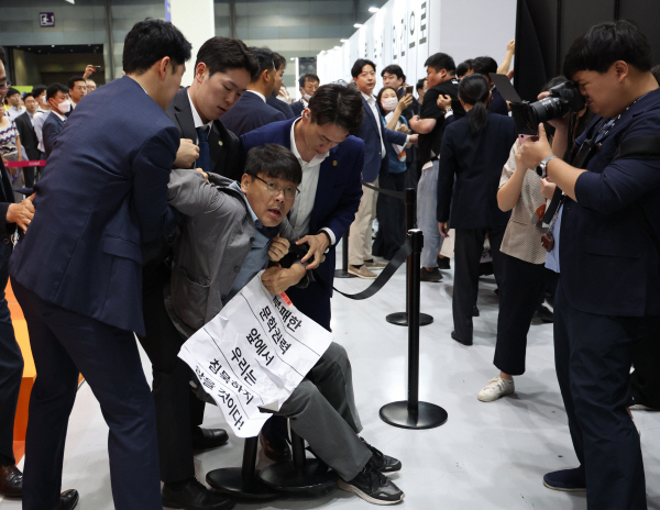 이날 문화예술인들은 기자회견 후 서울국제도서전을 관람하기 위하여 표를 사고 입장했으나 입구부터 경찰이 가로막았다. 김건희 여사가 개막식에 참석한다는 이유를 들어 경호구역이 아닌 공간에서부터 대통령실 경호원들이 예술인들을 과잉 진압했다는 설명이다. 항의하는 송경동 시인의 모습. (사진=연합뉴스)