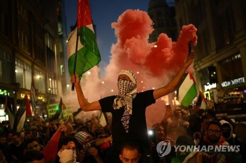 영국 런던의 팔레스타인 지지 시위= 지난 9일(현지시간) 팔레스타인 깃발을 든 시위대가 영국 런던의 이스라엘 대사관 근처에서 팔레스타인 지지 시위를 벌이고 있다.