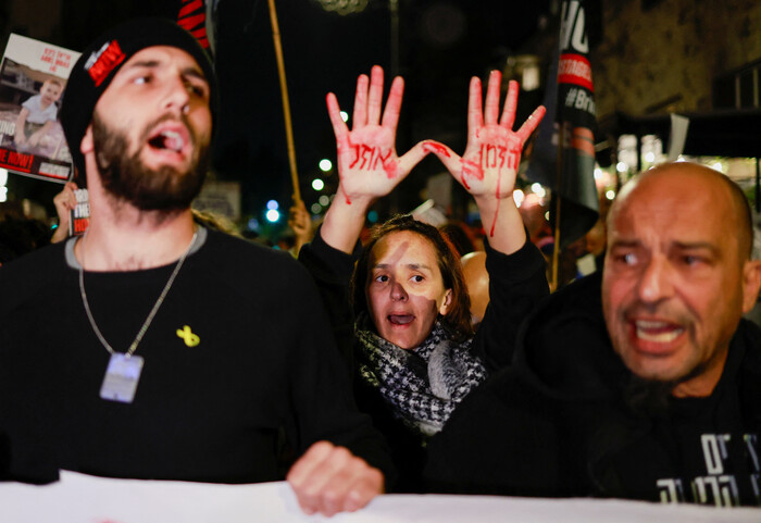 22일 이스라엘 네타냐후 총리 관저 부근에서 "시간이 흘러가고 있다"고 손에 글씨를 쓴 인질 가족들이 조속한 석방을 요구하며 시위를 하고 있다. (사진=로이터, 연합뉴스)