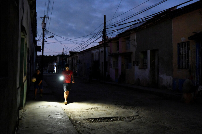 사진: 지난 8일(현지시간) 정전된 골목길을 휴대전화 불빛에 의지한 채 지나가는 쿠바 주민 [베후칼 로이터=연합뉴스]