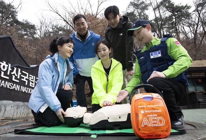 에스원 임직원이 공원 관계자에게 AED사용법을 안내하는 모습 (사진=에스원)
