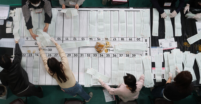 한땀 한땀 수개표 = 제22대 국회의원선거가 실시된 10일 오후 대구 남구 영남이공대학교 천마체육관 개표소에서 개표사무원들이 비례대표 투표지를 수개표하고 있다.