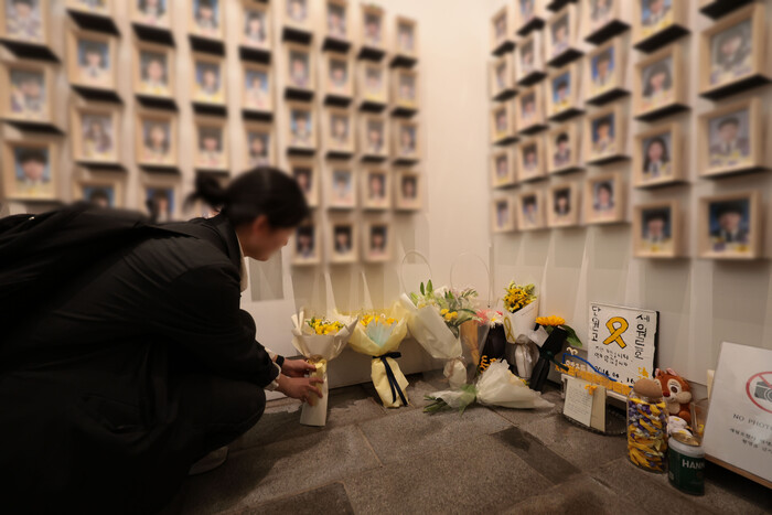 16일 서울 중구 서울시의회 앞 세월호 기억공간에서 열린 세월호 참사 10주기 시민 기억식에서 한 시민이 추모 꽃다발을 놓고 있다.