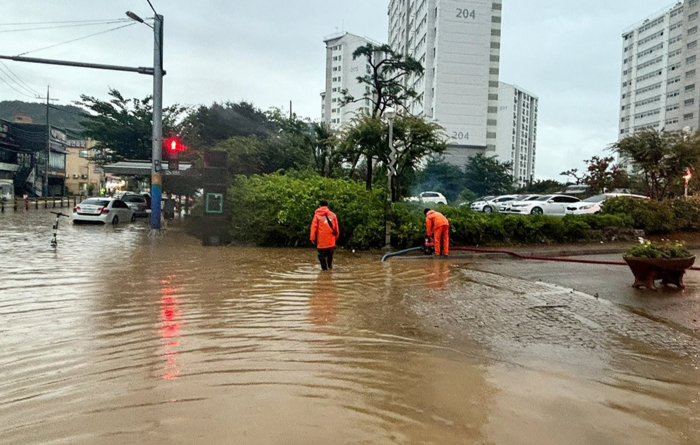 소방대원들이 도로가 침수돼 배수 작업을 하고 있다. 사진=소방서