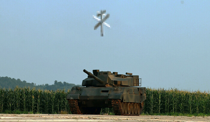 백색 계열로 도색한 북한의 자폭형 무인공격기가 날아가 K-2전차로 보이는 모의 표적을 타격하는 모습. (사진= 조선중앙통신, 연합뉴스)