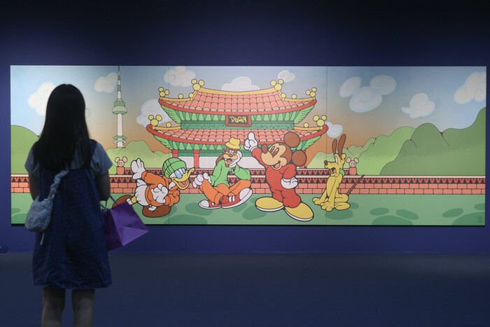 덕수궁에서 만나는 디즈니 = 27일 서울 덕수궁에서 열린 '미키 in 덕수궁 아트, 경계를 넘어서' 전시 개막식에서 참석자들이 참여 작가의 작품을 살펴보고 있다. ⓒ연합뉴스