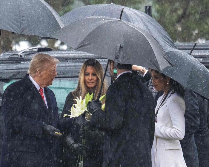 도널드 트럼프 당선인(왼쪽부터)과 멜라니아 트럼프 여사가 19일(현시시각) 버지니아주 알링턴묘지에서 묘비 위에 올려놓을 코인을 들고 있다. 미국은 고인에게 동전을 바치는 관행이 있어 이 코인은 진짜 코인이다. (사진=AFP 연합뉴스)