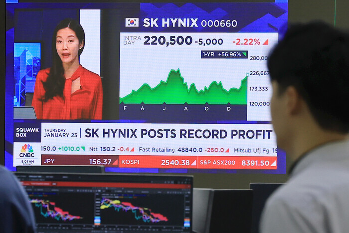 23일 서울 중구 하나은행 본점 딜릴룸에서 딜러들이 SK하이닉스 실적을 전하는 외신 보도를 보고 있다.(사진=연합뉴스)